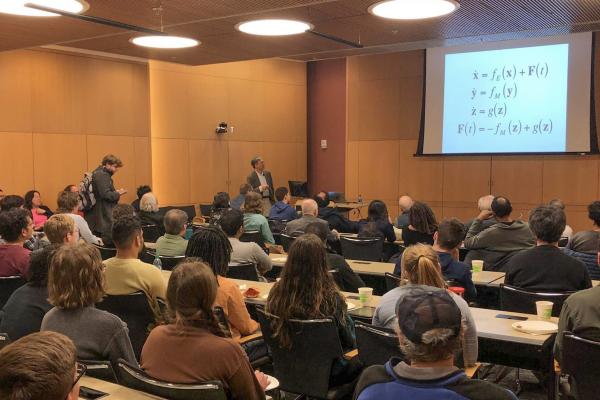 Kenneth Chang lecturing to audience.