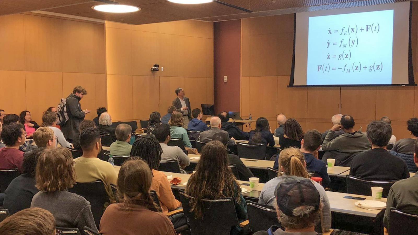 Kenneth Chang lecturing to audience.